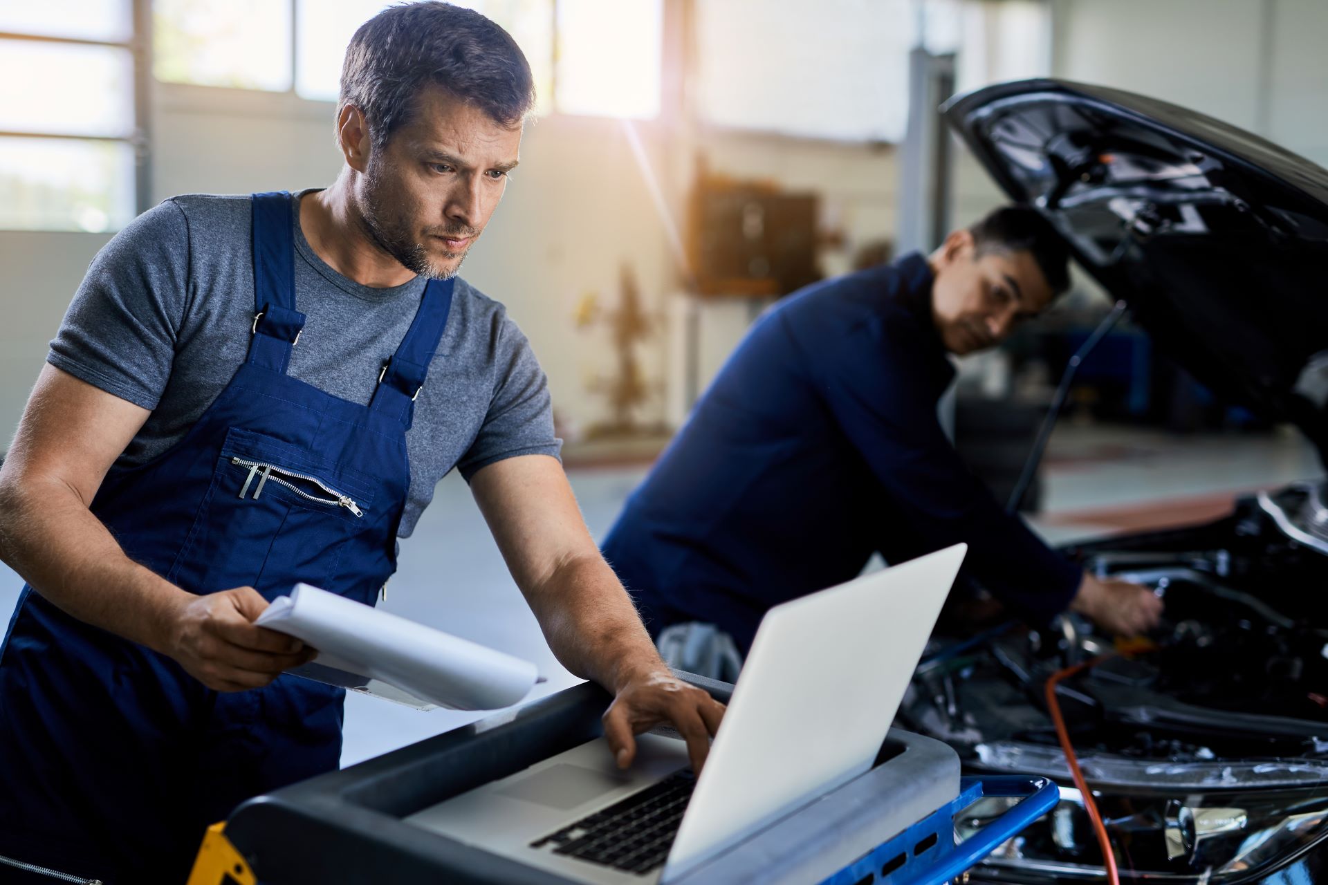 mid-adult-mechanic-using-laptop-car-diagnostic-while-working-with-colleague-auto-repair-shop.jpg